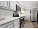 Open kitchen with stainless steel appliances, light gray cabinets, and modern subway tile backsplash at 3648 Peachtree Ne Rd # 2Q, Atlanta, GA 30319