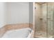 Bright bathroom featuring a separate tub and shower with tile surround and glass door at 375 Highland Ne Ave # 1011, Atlanta, GA 30312
