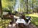 A backyard patio with outdoor seating and a grill, surrounded by lush green trees at 4257 Webb Rd, Tucker, GA 30084
