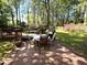 A backyard with a table and grill on the patio, surrounded by lush greenery and trees at 4257 Webb Rd, Tucker, GA 30084
