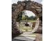 Stone archway frames outdoor seating area with unique fire pit, offering a tranquil and inviting gathering spot at 100 Carlyle Ln, Fayetteville, GA 30214