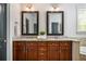 Bathroom featuring granite countertop, undermount sinks, dark wood cabinetry, and framed mirrors at 1233 Ashford Creek Ne Park, Atlanta, GA 30319