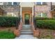 Inviting brick and stone townhome entrance with wrought iron railing leading up to a black front door at 1233 Ashford Creek Ne Park, Atlanta, GA 30319