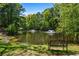 Scenic view of a pond with fountains, lush greenery, and a park bench at 1233 Ashford Creek Ne Park, Atlanta, GA 30319