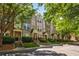 Row of townhomes featuring brick and stone exteriors, complemented by lush landscaping and mature trees at 1233 Ashford Creek Ne Park, Atlanta, GA 30319