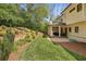 Lush backyard featuring a manicured lawn, retaining walls, beautiful garden area, and covered outdoor seating at 1282 Fairhill Ne Ln, Atlanta, GA 30319