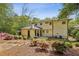 Expansive backyard with tiered landscaping, blooming azaleas, a small covered porch, and patio at 1282 Fairhill Ne Ln, Atlanta, GA 30319