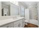 A bright bathroom features white cabinetry, a large mirror, and a shower-over-tub setup at 1282 Fairhill Ne Ln, Atlanta, GA 30319