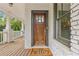 Close-up of a wooden front door on a brick home, with a charming porch and 'hello' welcome mat at 1282 Fairhill Ne Ln, Atlanta, GA 30319