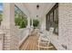 A comfortable front porch featuring white rocking chairs, brick columns, and wood decking at 1282 Fairhill Ne Ln, Atlanta, GA 30319