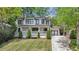 Charming two-story home featuring a manicured front lawn, classic white columns, and dark framed windows at 1282 Fairhill Ne Ln, Atlanta, GA 30319