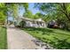 Charming single-story home featuring a welcoming front porch, a well-manicured lawn and a long driveway at 1305 Old Woodbine Rd, Atlanta, GA 30319