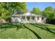 Charming one-story white home with a landscaped yard and beautiful lawn at 1305 Old Woodbine Rd, Atlanta, GA 30319