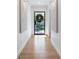 Hallway view with wooden floors, art, and a black door with a wreath at 1305 Old Woodbine Rd, Atlanta, GA 30319