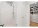 Shower with white tile, rainfall shower head, and view into the large walk-in closet at 1305 Old Woodbine Rd, Atlanta, GA 30319