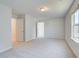 This bedroom features neutral carpeting, a window, and two doors at 2366 Cadenza Cir, Dacula, GA 30019