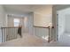 Bright hallway featuring a wrought iron railing, chandelier, and neutral carpet at 2366 Cadenza Cir, Dacula, GA 30019