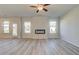Sunlit living room with modern fireplace, ceiling fan, and luxury vinyl plank flooring at 2366 Cadenza Cir, Dacula, GA 30019