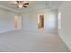 A bright main bedroom featuring a tray ceiling, fan, and multiple doors at 2366 Cadenza Cir, Dacula, GA 30019