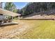 Large backyard with a covered patio, lawn, retaining wall and privacy trees at 4435 Bellwood Cir, Atlanta, GA 30349