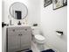 Chic half bathroom with a modern vanity, round mirror, and stylish fixtures at 4435 Bellwood Cir, Atlanta, GA 30349