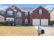 Traditional brick home featuring an attached two-car garage, well-maintained lawn and manicured shrubs at 4435 Bellwood Cir, Atlanta, GA 30349