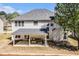 Rear exterior view of a two-story home with a covered patio, a spacious backyard, and a chimney at 4435 Bellwood Cir, Atlanta, GA 30349
