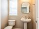 Powder room featuring a pedestal sink, decorative mirror, and window for natural lighting at 2145 Shoop Se Ct # 3, Smyrna, GA 30080