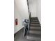 Carpeted staircase with metal railing, a bicycle, and a red fire extinguisher at 542 Goldsboro Ne Rd # C, Atlanta, GA 30307