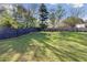 Expansive backyard with lush lawn, trees, and a dark wood fence at 1222 W Wylie Bridge Rd, Woodstock, GA 30188