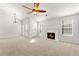 Spacious living room with a cozy fireplace, vaulted ceilings, natural light, and a modern ceiling fan at 1222 W Wylie Bridge Rd, Woodstock, GA 30188