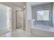 Primary bathroom features a tiled shower, soaking tub, and bright natural light at 128 Felicity Pike, Locust Grove, GA 30248