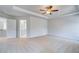 Large carpeted bedroom with ceiling fan, bright light and entry to bathroom at 128 Felicity Pike, Locust Grove, GA 30248