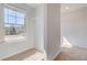 Bright, carpeted walk-in closet offers shelving and natural light from a window at 128 Felicity Pike, Locust Grove, GA 30248