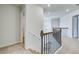 Bright hallway features wood and iron railing with a view of a pendant light fixture at 128 Felicity Pike, Locust Grove, GA 30248