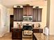 Well-equipped kitchen featuring dark wood cabinets, granite countertops, and modern appliances at 2269 Reddy Farm Ln, Grayson, GA 30017