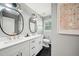 Stylish bathroom showcasing double sinks, modern fixtures, oval mirrors, and a combination of white and black tile at 2324 Bry Mar Ne Dr, Atlanta, GA 30345