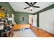 bedroom features green walls, a ceiling fan, fun decor, and hardwood floors, next to a closet at 2324 Bry Mar Ne Dr, Atlanta, GA 30345