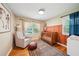Bedroom featuring hardwood floors, a stylish rug, an accent chair, and a crib adorned with neutral-toned decor at 2324 Bry Mar Ne Dr, Atlanta, GA 30345