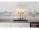 Close-up of a kitchen sink with subway tile backsplash and granite countertop, stainless steel appliances at 620 Peachtree Ne St # 1412, Atlanta, GA 30308