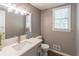 Bathroom features gray vanity with white countertop, modern faucet, decorative lighting and large mirror at 714 Lanford Springs Sw Dr, Lilburn, GA 30047