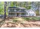 Charming two-story home features a large, covered front porch, and mature trees enhancing the landscape at 714 Lanford Springs Sw Dr, Lilburn, GA 30047
