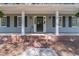 Charming front porch detail with brick steps and a decorative wreath on the black front door at 714 Lanford Springs Sw Dr, Lilburn, GA 30047