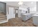 Open kitchen with white cabinets, gray island with quartz countertop, and stainless steel appliances at 714 Lanford Springs Sw Dr, Lilburn, GA 30047