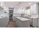 Well-lit kitchen features an island, white cabinets, gray base cabinets, and modern appliances at 714 Lanford Springs Sw Dr, Lilburn, GA 30047