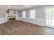 Spacious living room with hardwood flooring, fireplace, and natural light from two windows and glass panel door at 714 Lanford Springs Sw Dr, Lilburn, GA 30047