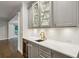 Stylish bar area features marble countertops, a wine fridge, glass front cabinets, and gold hardware at 8925 Huntcliff Lake Ct, Atlanta, GA 30350