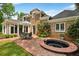 Back exterior view of a brick home featuring a jacuzzi, outdoor seating area, and well-manicured lawn at 8925 Huntcliff Lake Ct, Atlanta, GA 30350