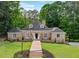 Charming brick home featuring a manicured lawn and inviting brick pathway leading to the front door at 8925 Huntcliff Lake Ct, Atlanta, GA 30350