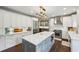 Spacious kitchen featuring white cabinets, a large island, and stainless steel appliances at 8925 Huntcliff Lake Ct, Atlanta, GA 30350